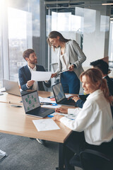 Beautiful business people are using gadgets, talking and smiling during the conference in office 