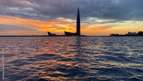 View from the yacht of the Gulf of Finland and the Lakhta Center skyscraper on the background of a pink sunset, the coastline,the tallest building in Europe.Russia,Saint Petersburg,14.04.2022