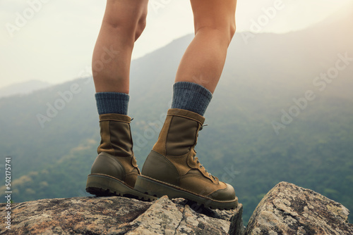 Suceesful woman hiker legs stand on mountain peak cliff edge © lzf