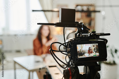 Canvas Print Video camera with young female blogger or advert model on screen standing in spa