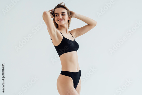 Young beautiful woman body on white background in black sport lingerie