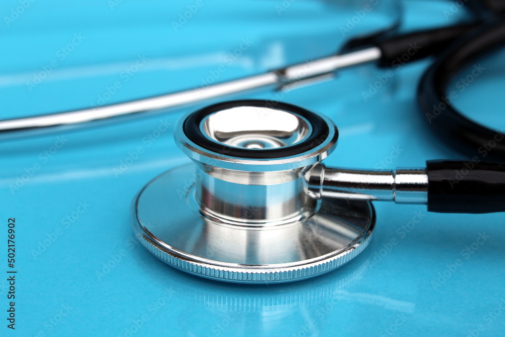 An iron stethoscope lies on a blue background. An iron stethoscope lies on a blue background.