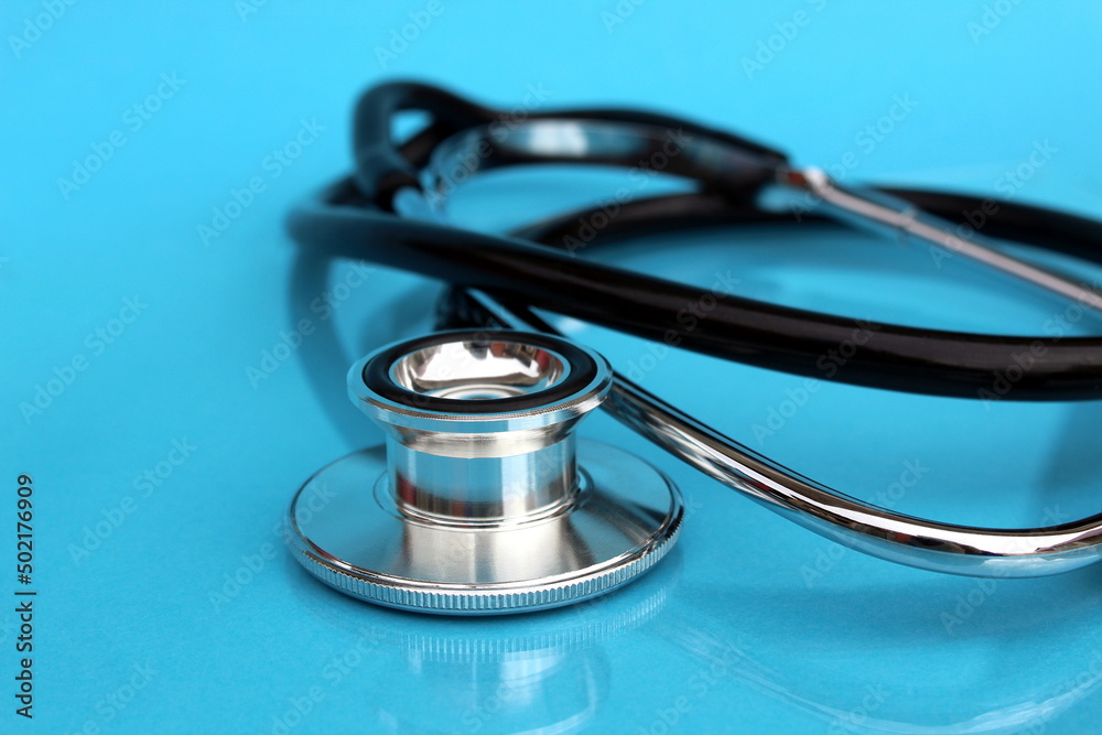 An iron stethoscope lies on a blue background. An iron stethoscope lies on a blue background.