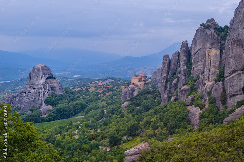 View of Monastery of St. Nicholas Anapavsas on top of a sheer cliff. The miracle of Meteora - harmony of man and nature in Greece. A popular travel and pilgrimage destination