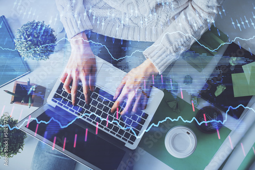 Double exposure of woman hands working on computer and forex chart hologram drawing. Top View. Financial analysis concept.