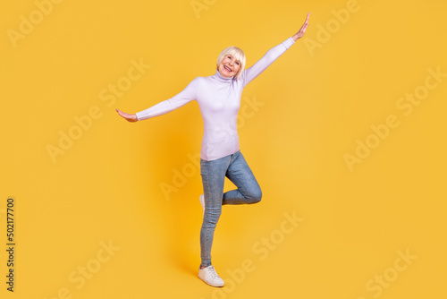 Full size photo of cheerful mature woman have fun excited dance free-time isolated over yellow color background