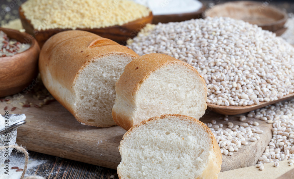 wheat baguette on the table with flour and various plant grains wheat baguette on the table with flour and various plant grains