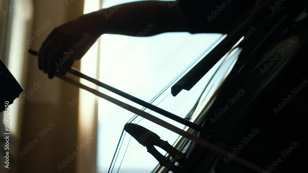 Cello player playing simple melody indoors. Cello player playing simple melody indoors.