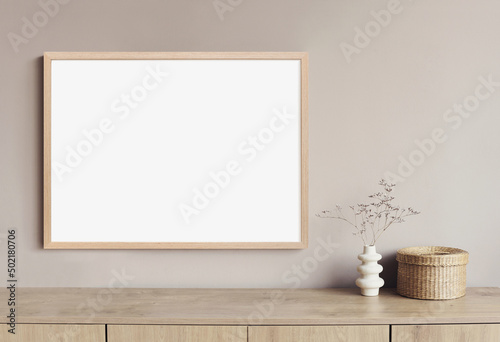 Blank picture frame mockup on gray wall. White living room design. View of modern scandinavian style interior with artwork mock up on wall. Home staging and minimalism concept