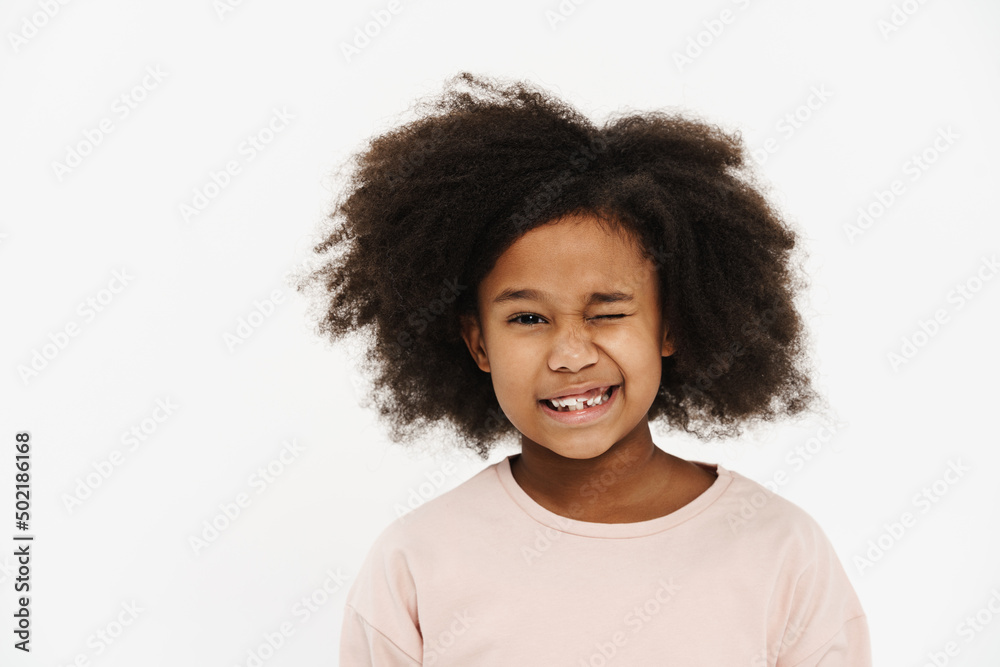 Black preteen girl with curly hair smiling and winking at camera Black preteen girl with curly hair smiling and winking at camera