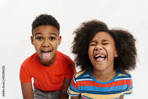 Black boy and girl showing their tongues together at camera
