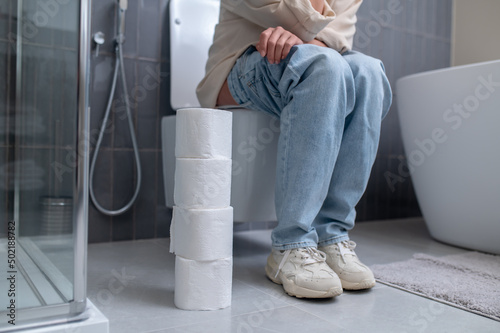 фотографія A young woman sitting on a toilet bowl
