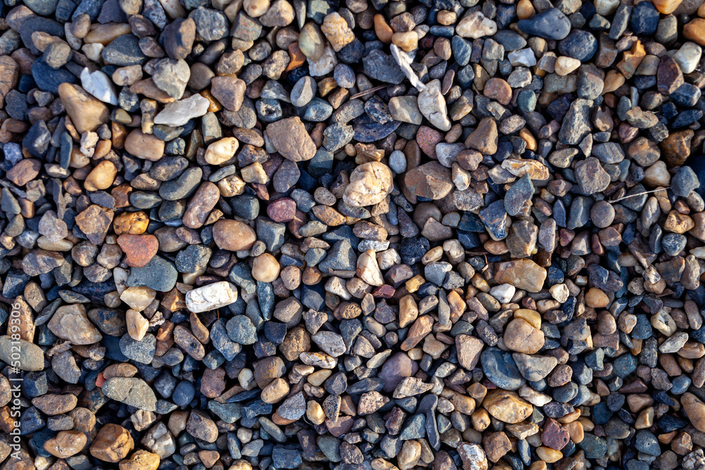 Crushed stone on the seashore. Selective focus on object. The stones were laid on the ground in the garden as a background. Background blur. Pebble stones background. Crushed stone on the seashore. Selective focus on object. The stones were laid on the ground in the garden as a background. Background blur. Pebble stones background.
