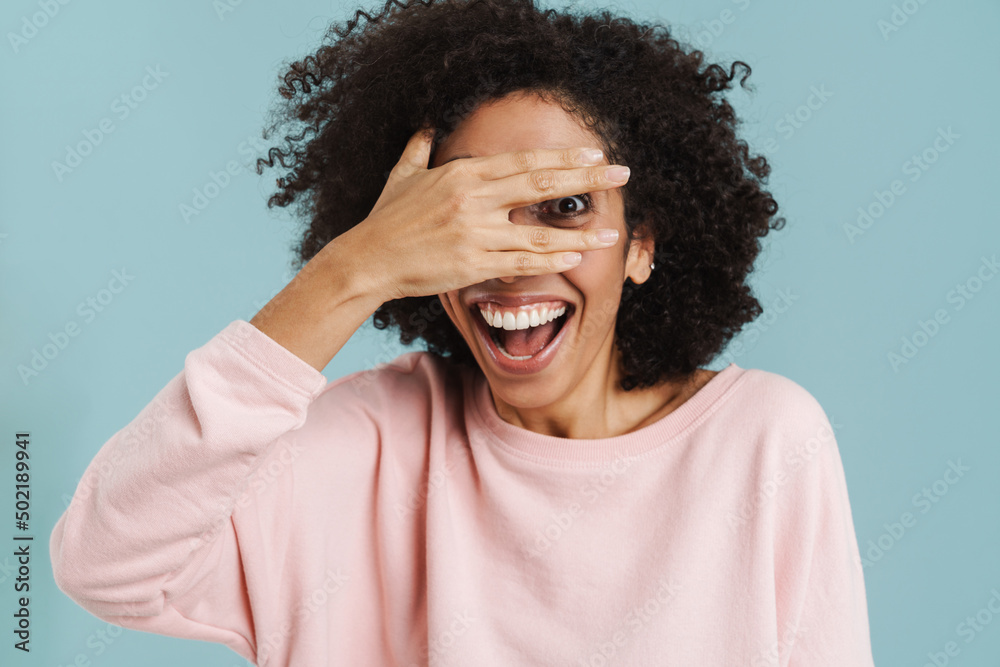 Black young woman laughing while covering her eyes Black young woman laughing while covering her eyes