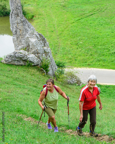 Zwei wandernde Seniorinnen an der Felsformation der Steinernen Jungfrauen im Brenztal photo