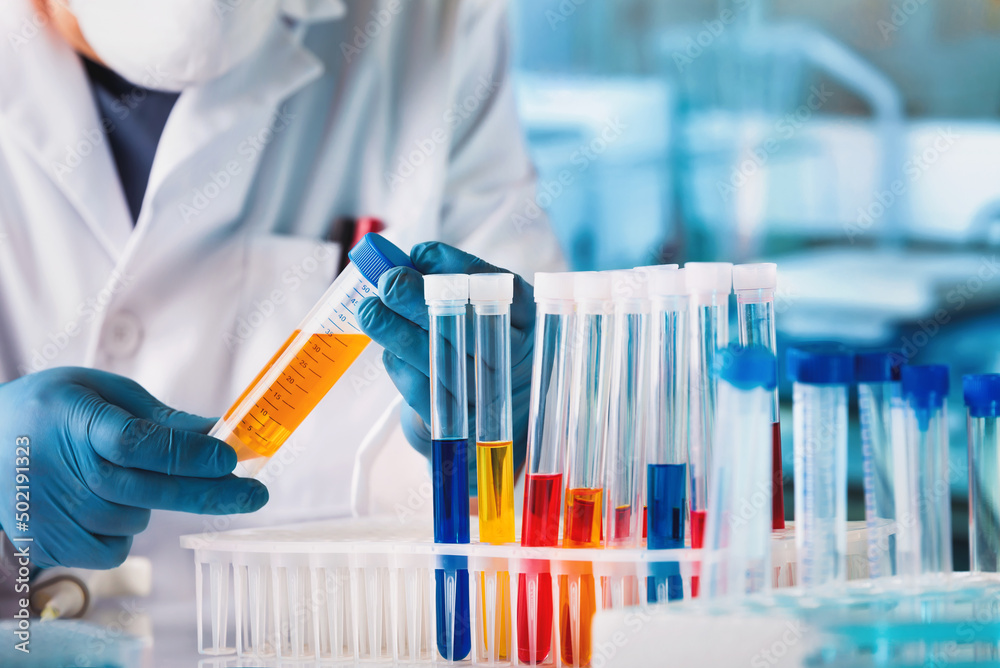 Scientist working with chemical material samples in biotechnology lab. Technician examining test tube in the Medical Research Laboratory Scientist working with chemical material samples in biotechnology lab. Technician examining test tube in the Medical Research Laboratory