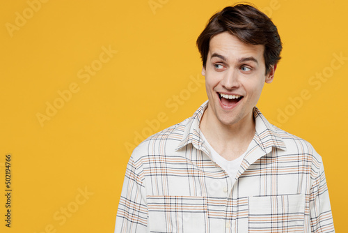 Cuadro en lienzo Young smiling surprised happy caucasian man 20s wearing white casual shirt look aside on workspace area mock up isolated on plain yellow background studio portrait