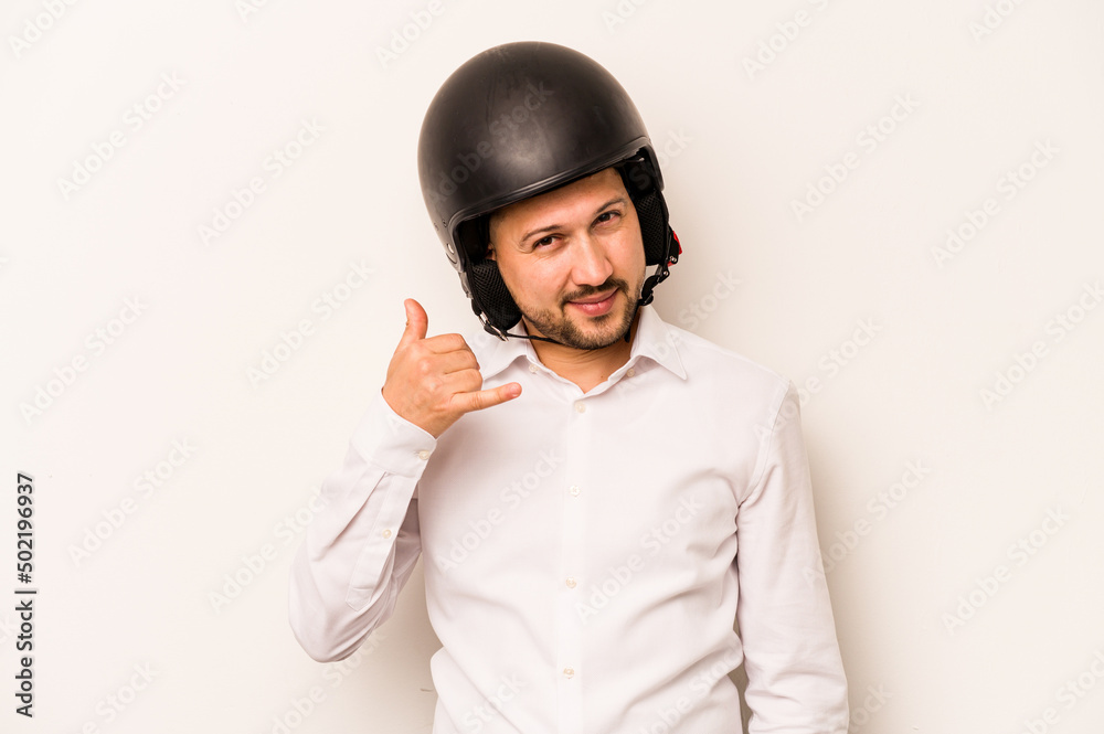 Hispanic business man going to work with motorcycle isolated on white background showing a mobile phone call gesture with fingers. Hispanic business man going to work with motorcycle isolated on white background showing a mobile phone call gesture with fingers.