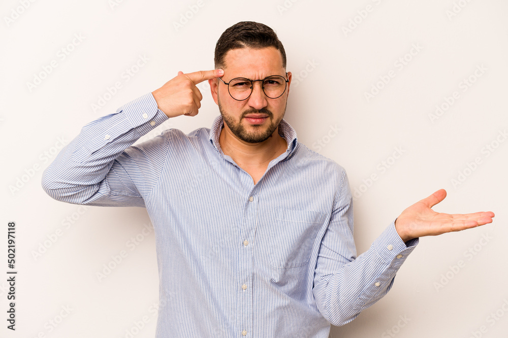 Naklejka premium Young hispanic man isolated on white background holding and showing a product on hand.