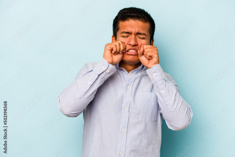 Young hispanic man isolated on blue background whining and crying disconsolately. Young hispanic man isolated on blue background whining and crying disconsolately.