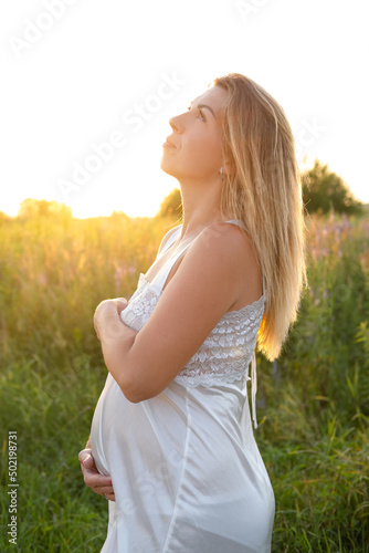 Future mom expecting baby. Copy space. Pregnancy, maternity, expectation concept. beautiful woman in white nightie with big tummy outside.