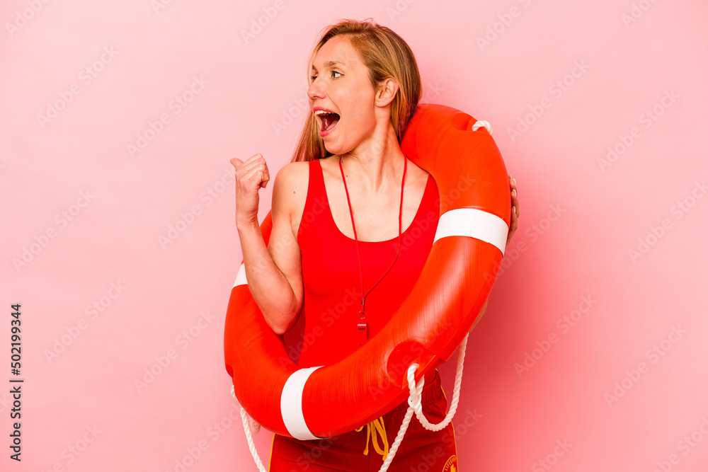 Young caucasian life guard woman isolated on pink background points with thumb finger away, laughing and carefree. Young caucasian life guard woman isolated on pink background points with thumb finger away, laughing and carefree.