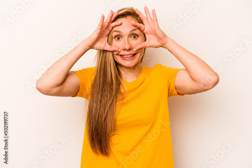 Young caucasian woman isolated on white background keeping eyes opened to find a success opportunity.