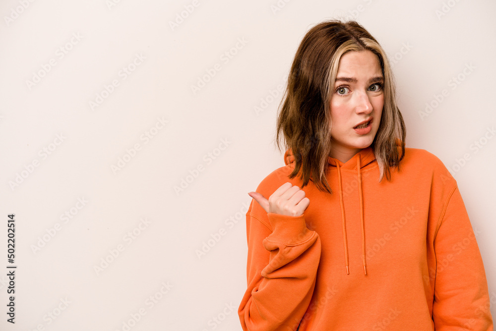 Young caucasian woman isolated on white background shocked pointing with index fingers to a copy space. Young caucasian woman isolated on white background shocked pointing with index fingers to a copy space.