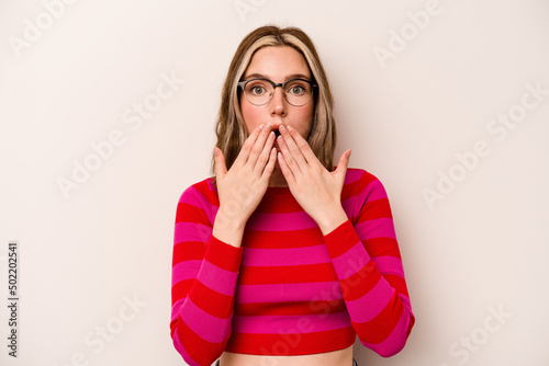 Young caucasian woman isolated on white background shocked covering mouth with hands.