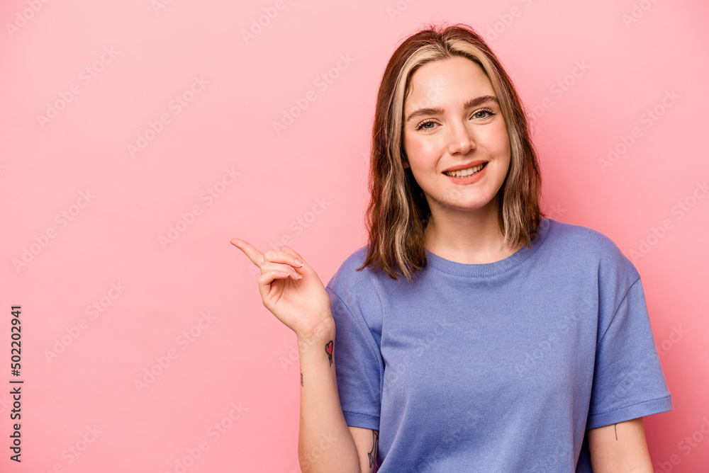 Young caucasian woman isolated on pink background smiling cheerfully pointing with forefinger away. Young caucasian woman isolated on pink background smiling cheerfully pointing with forefinger away.