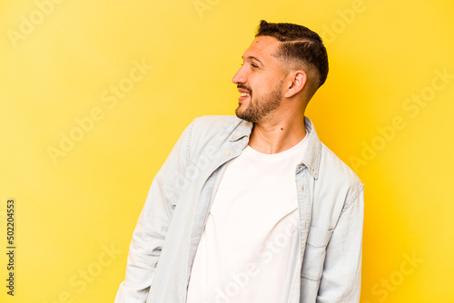 Young hispanic man isolated on yellow background relaxed and happy laughing, neck stretched showing teeth.