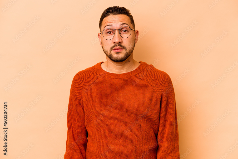Young hispanic man isolated on beige background sad, serious face, feeling miserable and displeased. Young hispanic man isolated on beige background sad, serious face, feeling miserable and displeased.