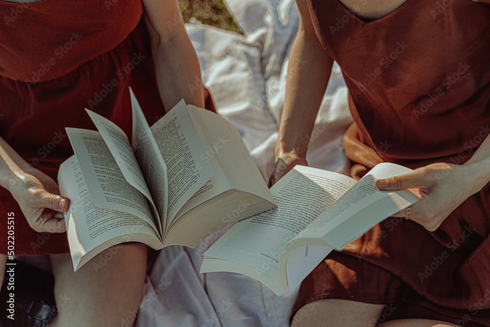 Obraz premium Happy multi-ethnic girls studying outside in the countryside. 