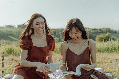 Happy girls studying outside in the spring season.  © Luana