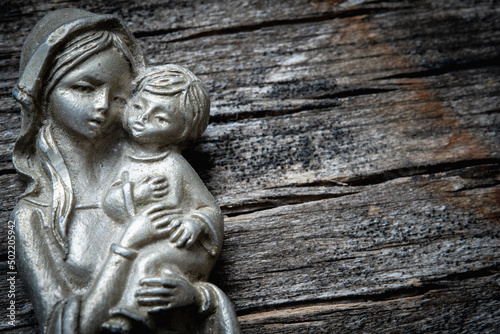 Fotografija Virgin Mary with the baby Jesus Christ against wooden background