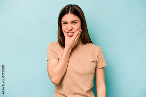 Young caucasian woman isolated on blue background having a strong teeth pain, molar ache. © Asier