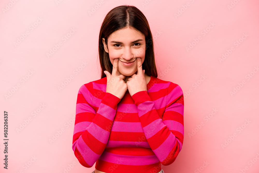 Young caucasian woman isolated on pink background doubting between two options. Young caucasian woman isolated on pink background doubting between two options.