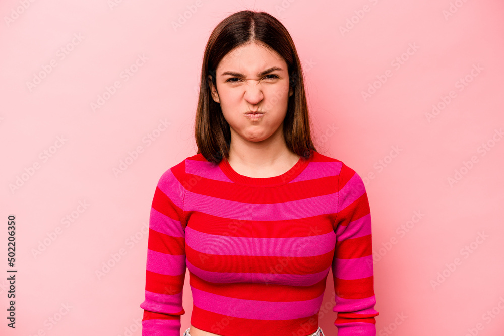 Young caucasian woman isolated on pink background blows cheeks, has tired expression. Facial expression concept. Young caucasian woman isolated on pink background blows cheeks, has tired expression. Facial expression concept.