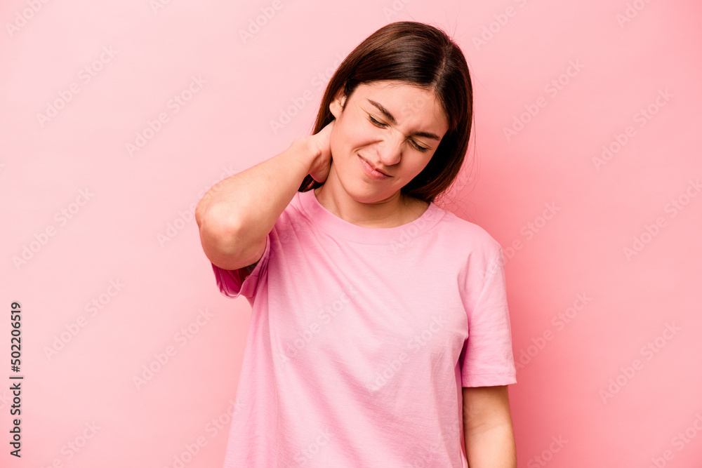 Young caucasian woman isolated on pink background having a neck pain due to stress, massaging and touching it with hand.