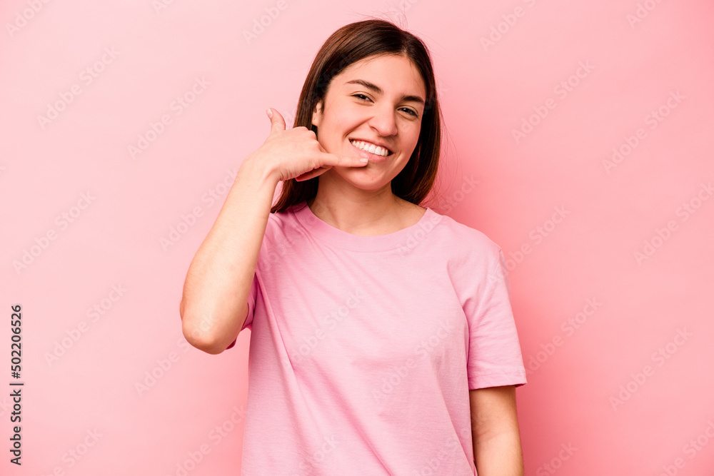 Young caucasian woman isolated on pink background showing a mobile phone call gesture with fingers. Young caucasian woman isolated on pink background showing a mobile phone call gesture with fingers.