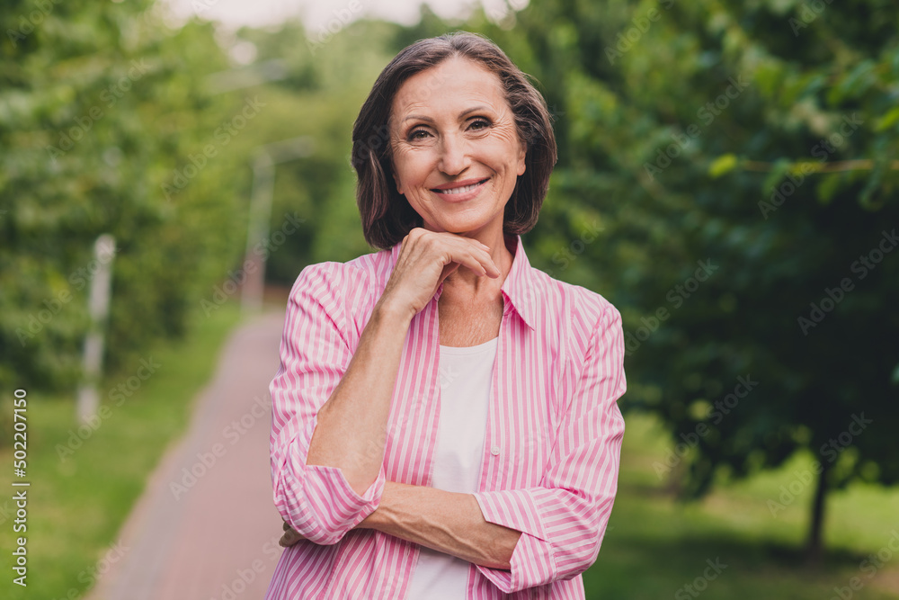 Photo of pretty charming lady pensioner wear pink shirt walking hand arm chin outdoors countryside garden Photo of pretty charming lady pensioner wear pink shirt walking hand arm chin outdoors countryside garden