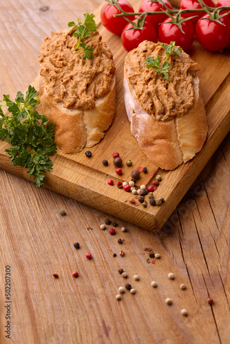 Fresh homemade chicken liver pate on bread over rustic background.Selective focus