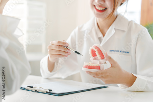 Portrait of a female dentist She is recommending dental care methods in her dentist's office.