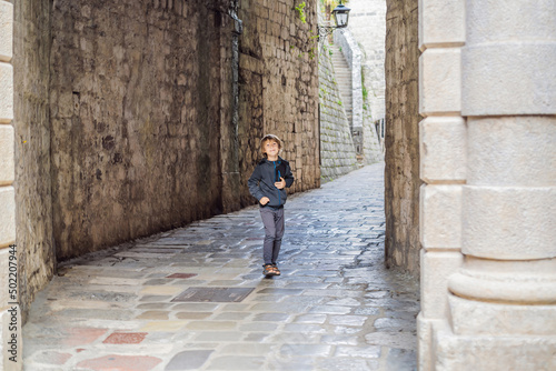 Boy tourist enjoying Colorful street in Old town of Kotor on a sunny day, Montenegro. Travel to Montenegro concept