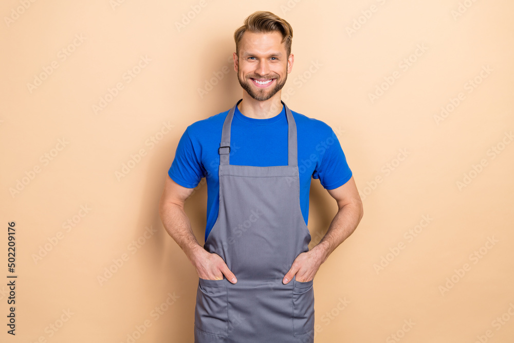 Photo of cheerful friendly person hands pockets look camera beaming smile isolated on beige color background Photo of cheerful friendly person hands pockets look camera beaming smile isolated on beige color background