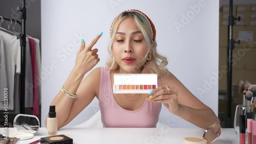 Young beautiful Asian woman and professional beauty make up artist vlogger or blogger recording makeup tutorial to share on website or social media. Business online influencer on social media concept.