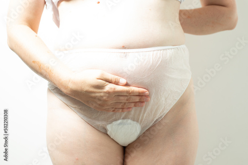 Female postpartum belly in disposable underpants, hygiene photo