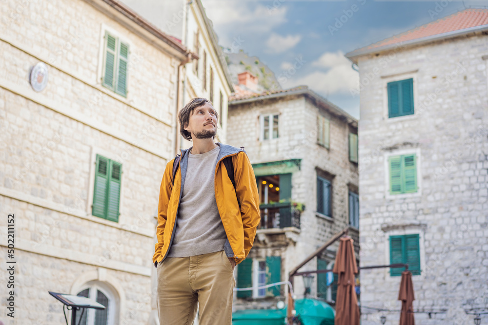 Man tourist enjoying Colorful street in Old town of Kotor on a sunny day, Montenegro. Travel to Montenegro concept