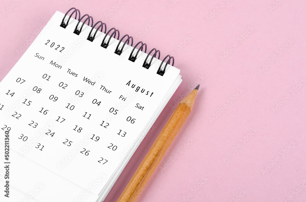 August 2022 desk calendar with wooden pencil on pink background. August 2022 desk calendar with wooden pencil on pink background.