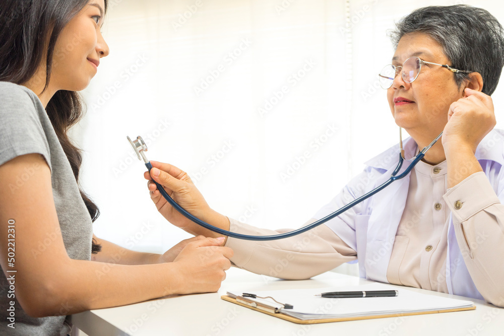 Female Asian doctor use a stethoscope for diagnosis young female patient in clinic or hospital. Doctors consultation idea. Healthcare and medicine concept. Female Asian doctor use a stethoscope for diagnosis young female patient in clinic or hospital. Doctors consultation idea. Healthcare and medicine concept.